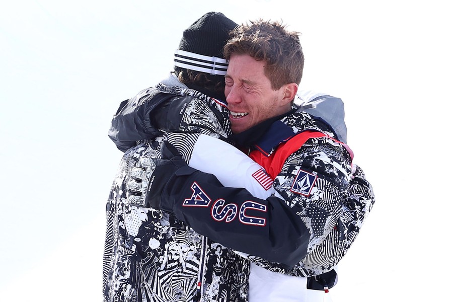 Snowboarder Shaun White hugs a coach after an event.