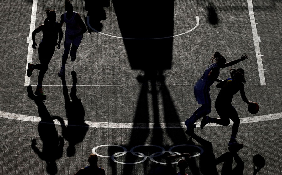 Basketball players play on a half-court.