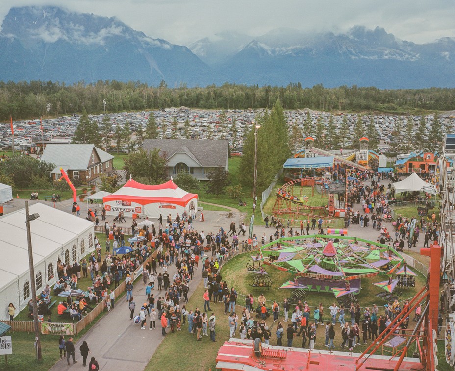 State Fair seen from above with rides, people and mountains in the frame.