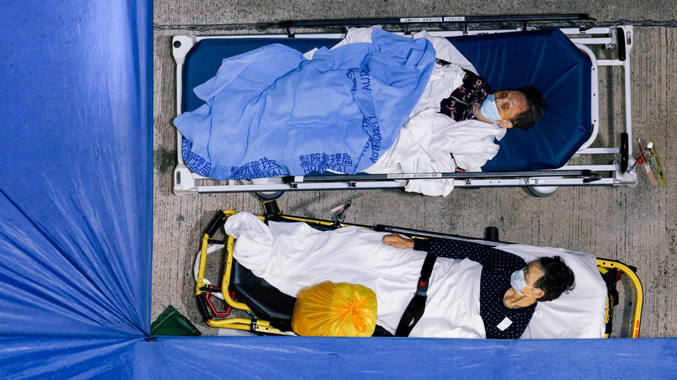 Patients sleep at a makeshift COVID-19 treatment area outside a hospital.