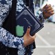 A Muslim refugee holds a Koran in Lesbos, Greece