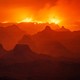 A night view of a smoky Grand Canyon, with a wildfire burning along the far rim.