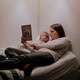A mother reads 'Frog and Toad' with a toddler in bed