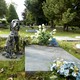 Gravestones, flowers, and a statue of a dog