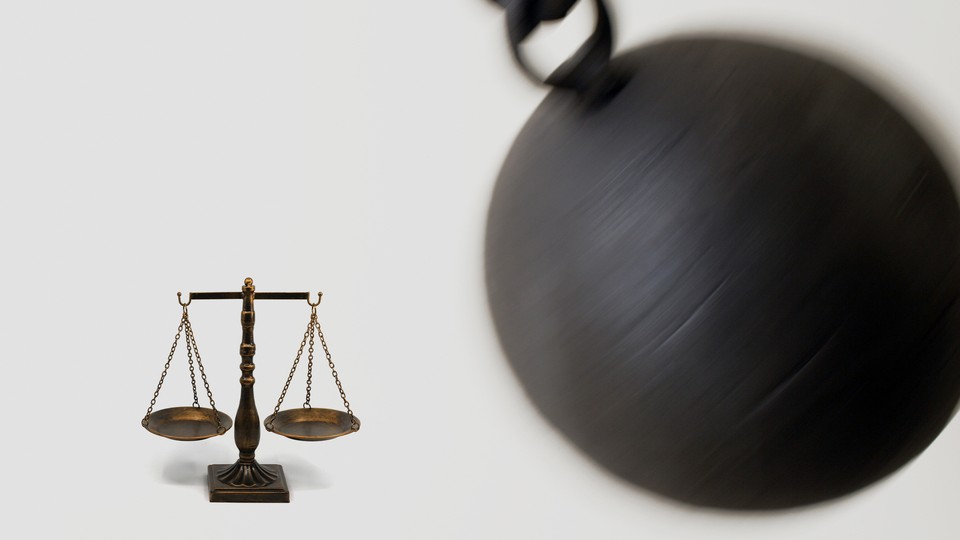 An image of a wrecking ball about to hit the scales of justice