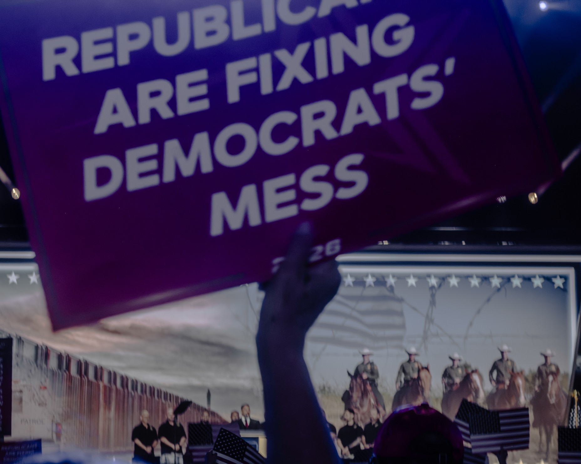 a person holds a sign in front of a stage