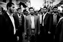 A man in a suit surrounded by other men in suits