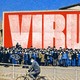 An illustration of Chinese nationals with a sign spelling out "VIRU.S." behind them.