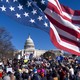 An American flag flies above a group of protesters gathered near the U.S. Capitol Building.
