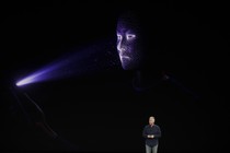 Phil Schiller stands in front of a screen demonstrating the Face ID feature of the iPhone X.