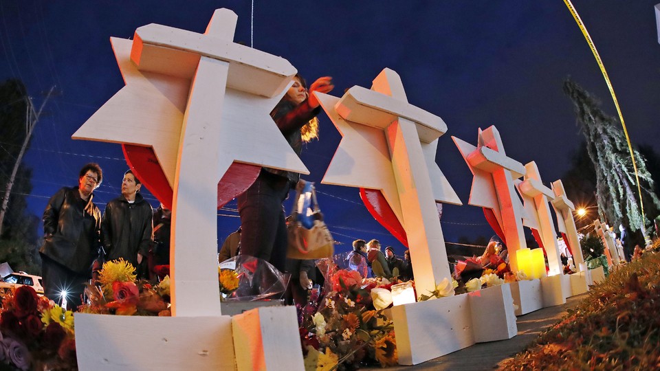 People gather around candlelit memorials.