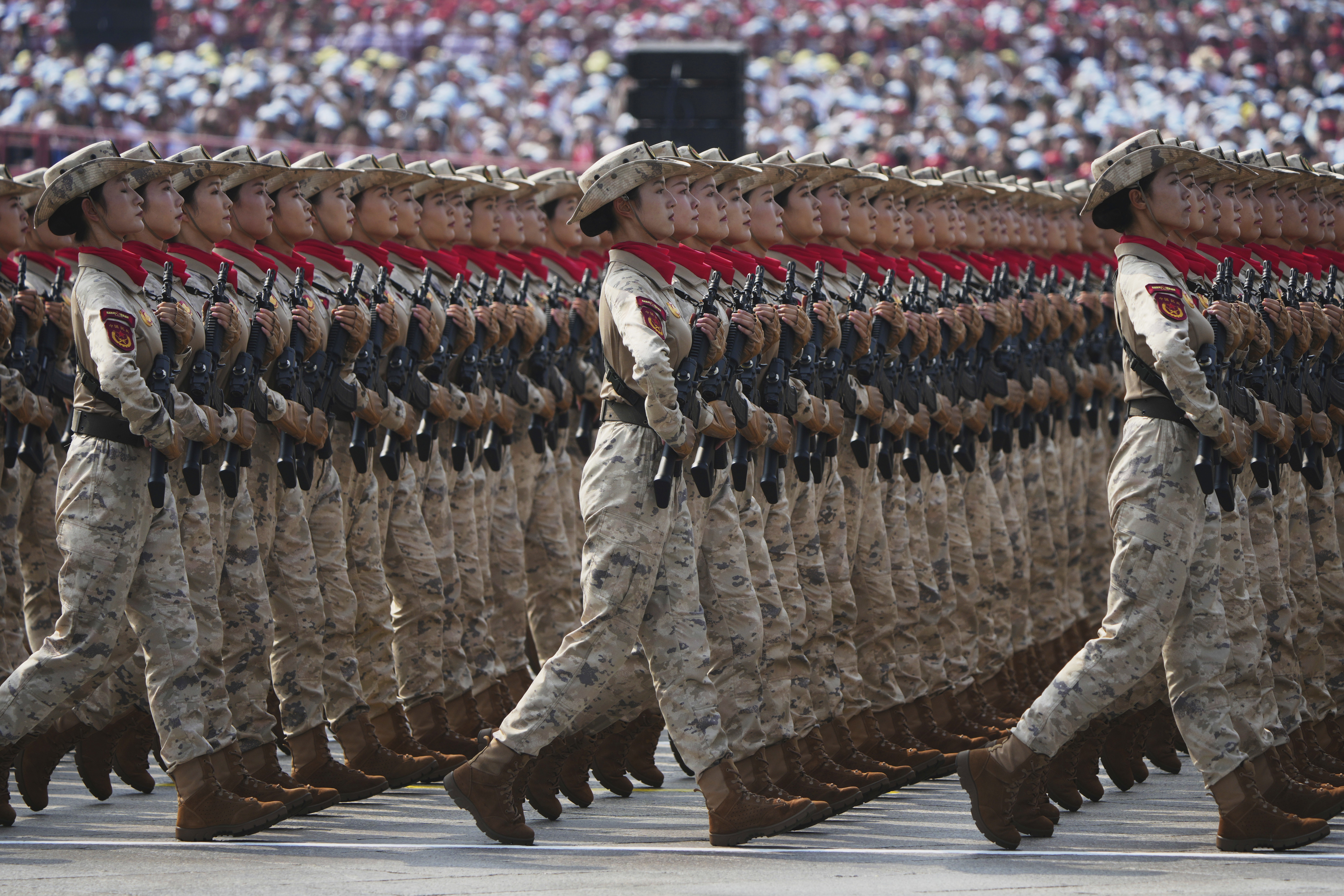 Several lines of soldiers march in unison during a parade.