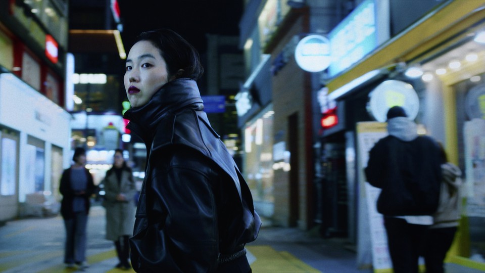 Park Ji-min looking over her shoulder while walking down a street in Seoul in "Return to Seoul"