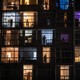 People in windows viewed through balconies