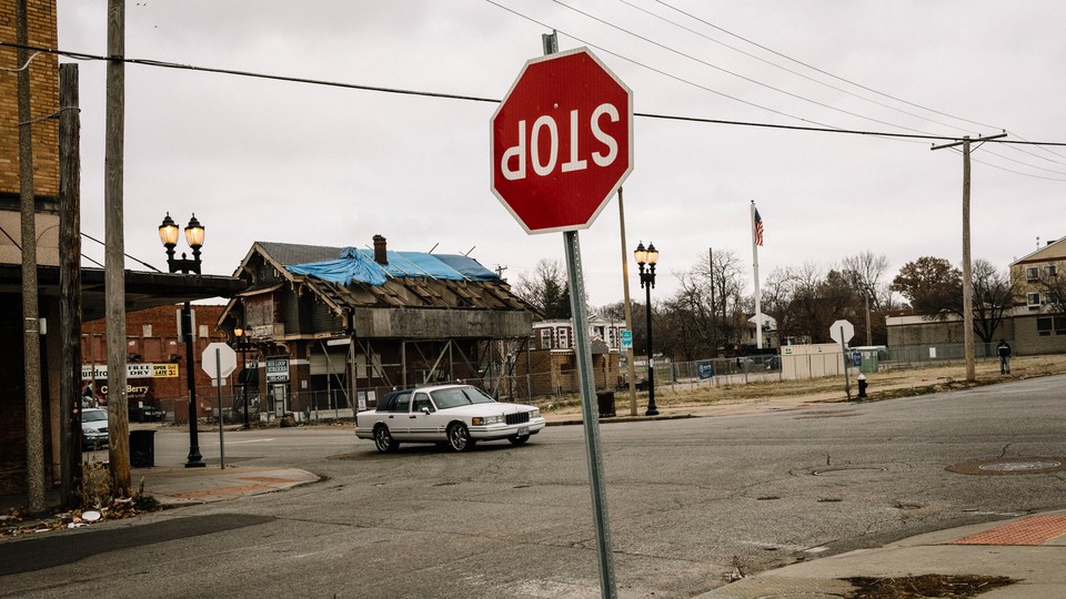 a street in a state of abandonment and disrepair with an upside down Stop sign