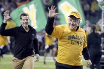 Baylor University President Ken Starr gestures the Sic'em as he leads the freshman class on a run across the field before the start of an NCAA college football game.