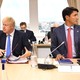 Boris Johnson and Justin Trudeau sit alongside each other at a table.