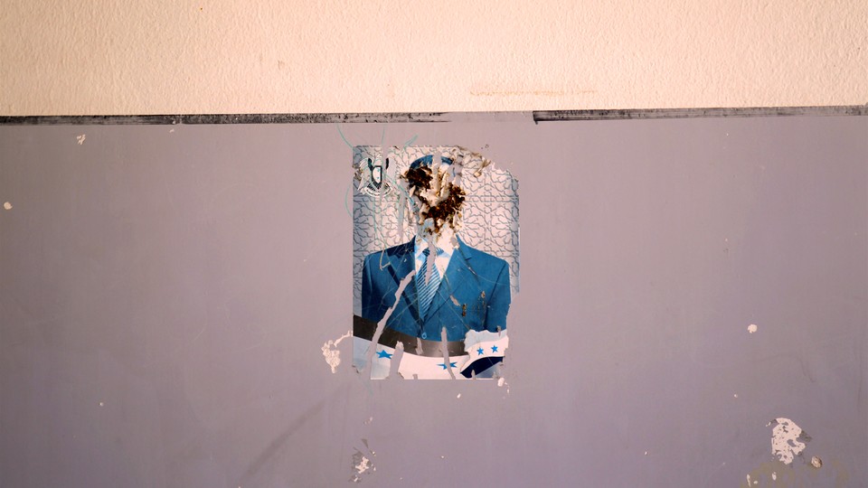 A defaced image of Syria's President Bashar al-Assad on a wall inside a school in Idlib province