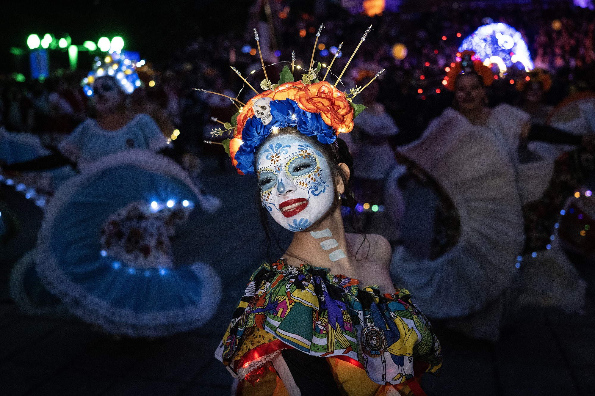 A woman dressed as a Catrina takes part in a parade.