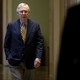 Mitch McConnell walks through a hallway.