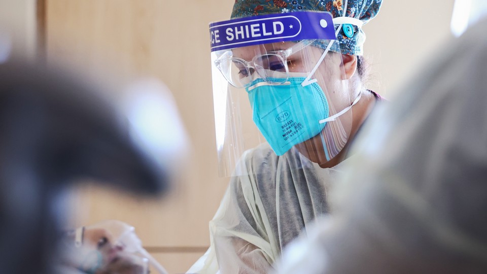 A nurse wearing a face mask and face shield