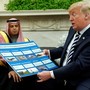 Donald Trump holds a chart of military hardware sales as he welcomes Saudi Arabia's Crown Prince Mohammed bin Salman in the Oval Office in May 2018