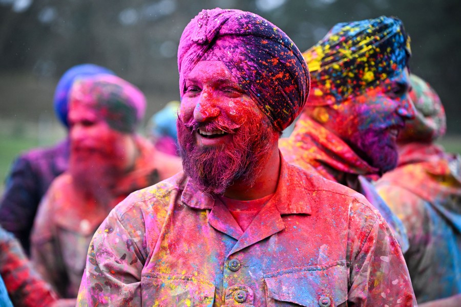 Several soldiers smile, covered in bright colored powder.