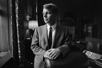 A black and white portrait of Robert F. Kennedy, then attorney general of the United States, posing in an office