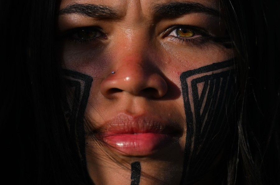 A close view of a person's face painted with tribal markings