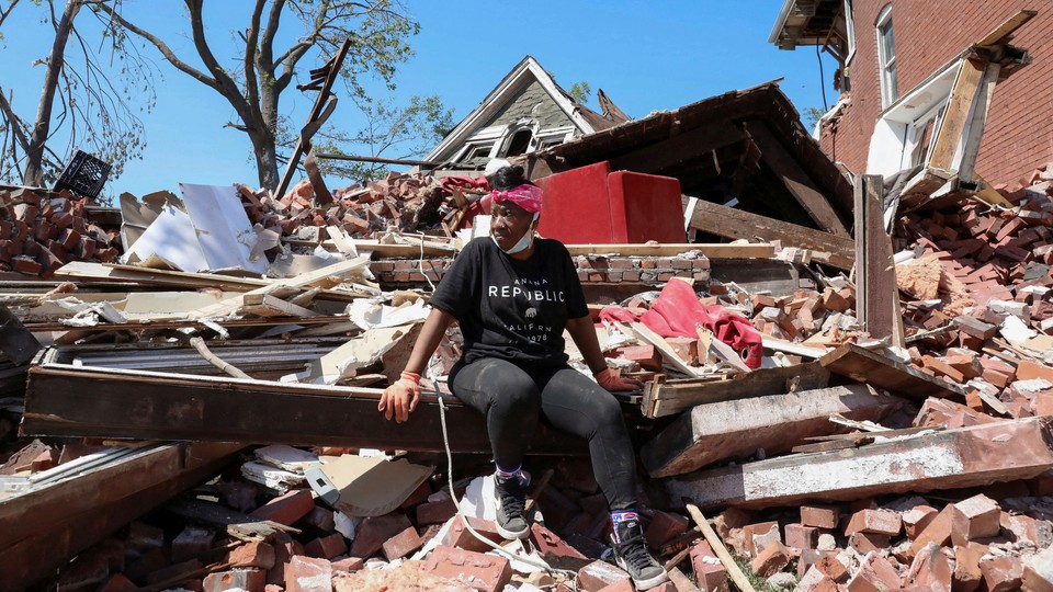 A woman sits on the wreckage of her home caused by a tornado in St. Louis, Missouri, May 18, 2025