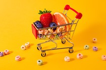 A miniature cart holding fruit slices and colorful cereal