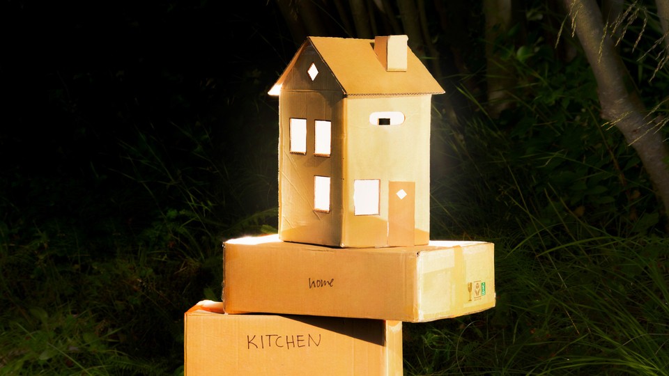 photo of cardboard moving boxes, one of which is shaped like a house