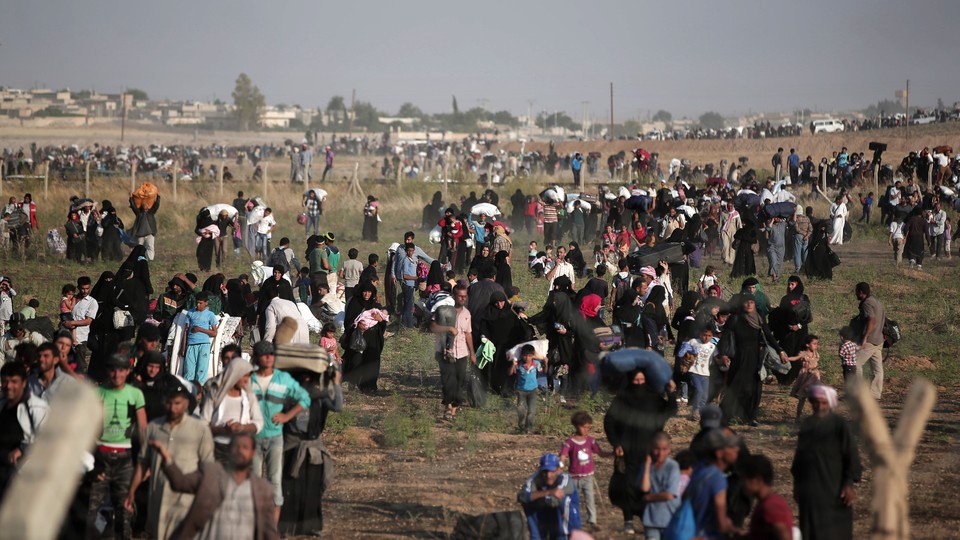 Thousands of Syrian refugees walk in order to cross into Turkey in June 2015.  