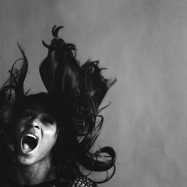 Studio portrait of American rock singer Tina Turner, wearing a dark crocheted mini-dress, singing while her long dark hair flies around her face, New York, New York, November 25, 1969.