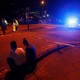 People sit by the side of the road next to a police cordon outside the Manchester Arena.