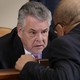 Representative Peter King of New York speaking with a colleague in a congressional hearing room
