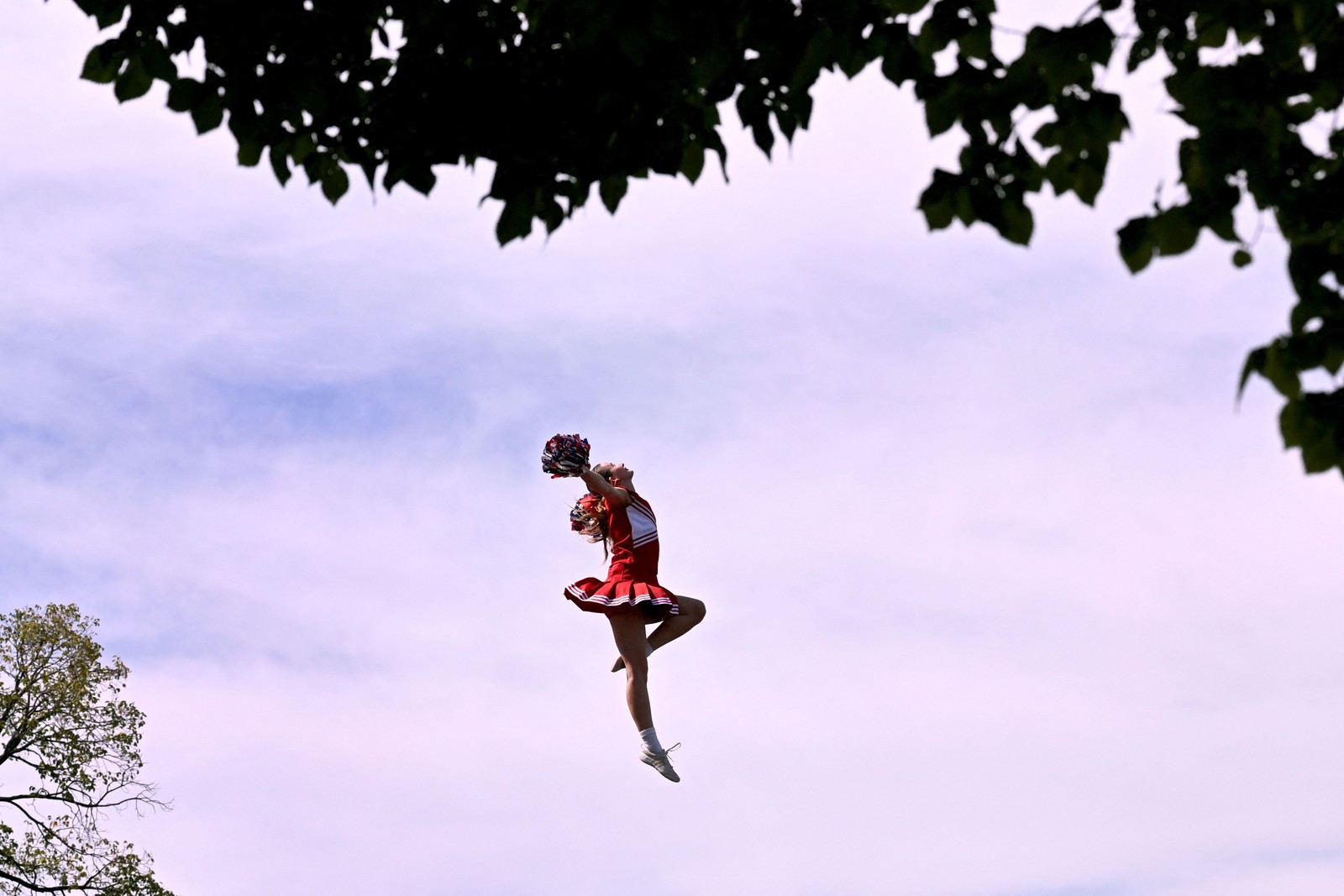 A cheerleader in the air, mid-jump