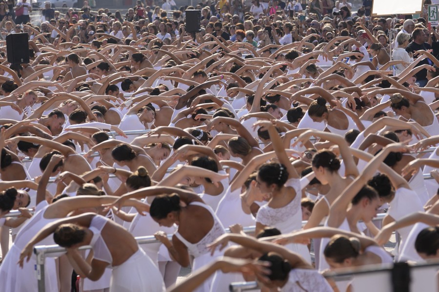 A view of dozens of dancers performing together outside