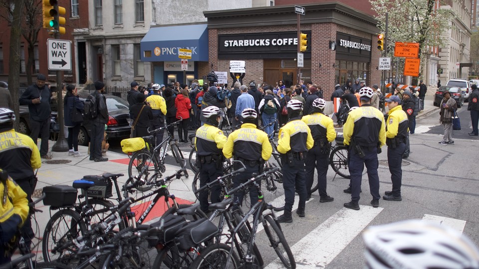 Police stand outside of a Starbucks. 