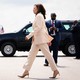 Kamala Harris striding toward an open car door