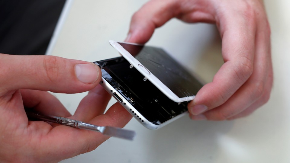 A technician repairing a broken iPhone