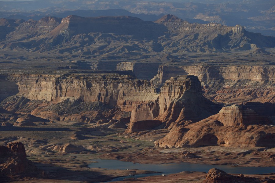 A broad view of a deep canyon with a dwindling reservoir.