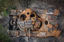 An overhead view of a rusting destroyed tank