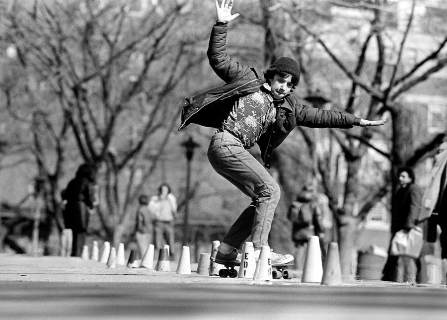 A teenager rides a skateboard in a park.