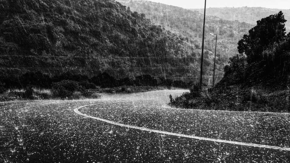 Torrential hail pours down on a winding mountain road