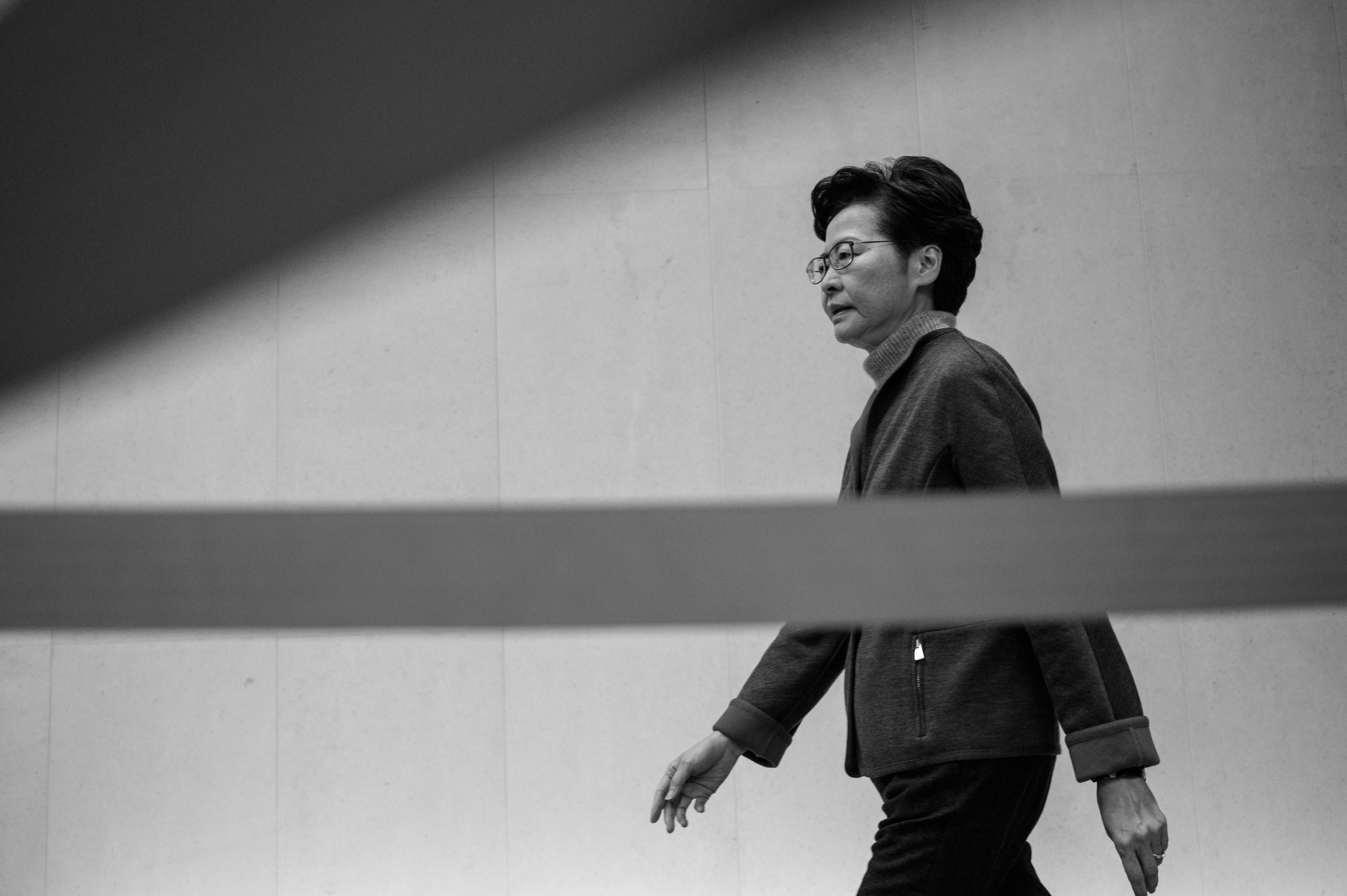Hong Kong chief executive Carrie Lam walks to her right.