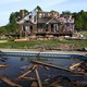 Debris floats in a pool near a severely storm-damaged house.
