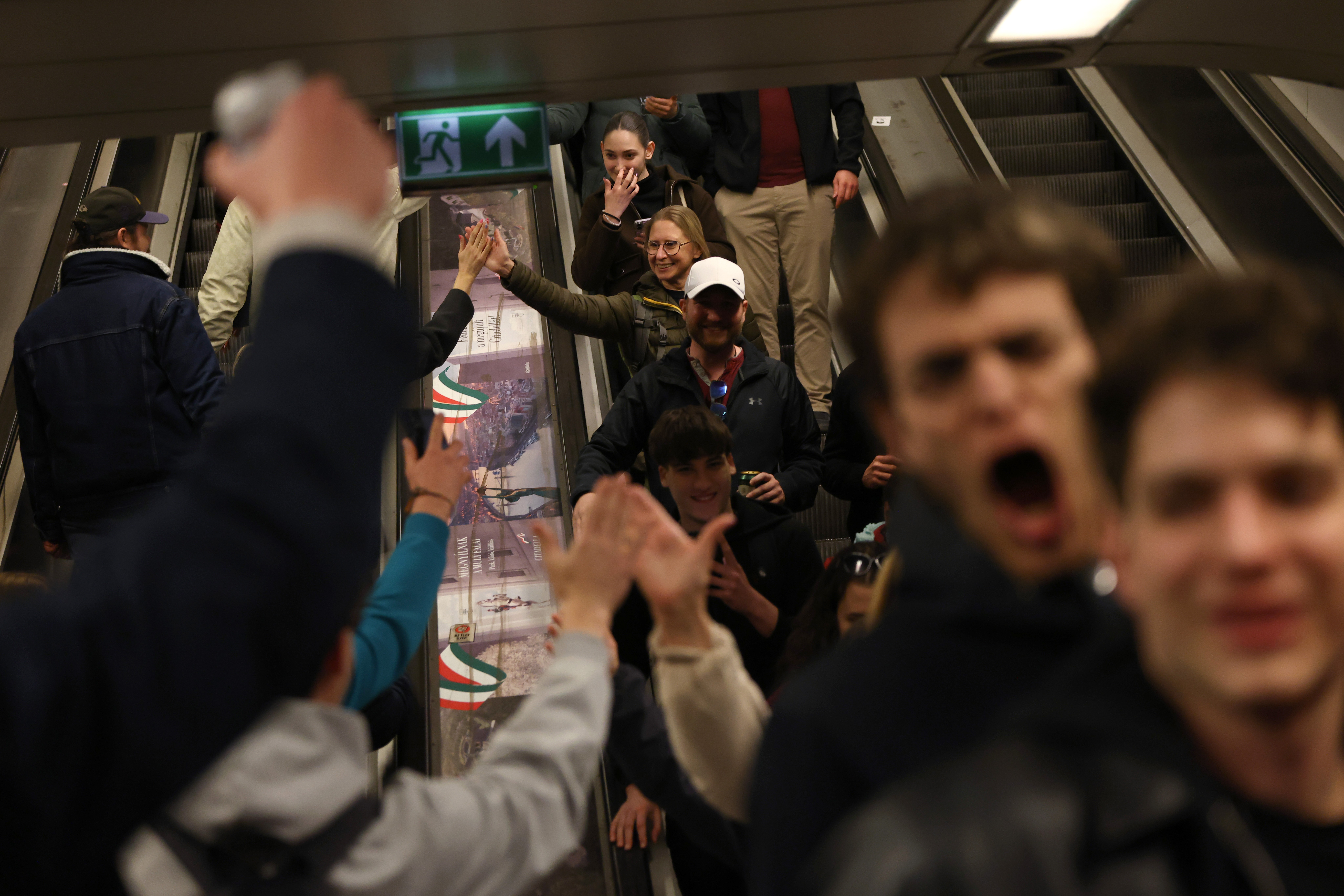 Happy people greeting each other on an escalator in a subway station.