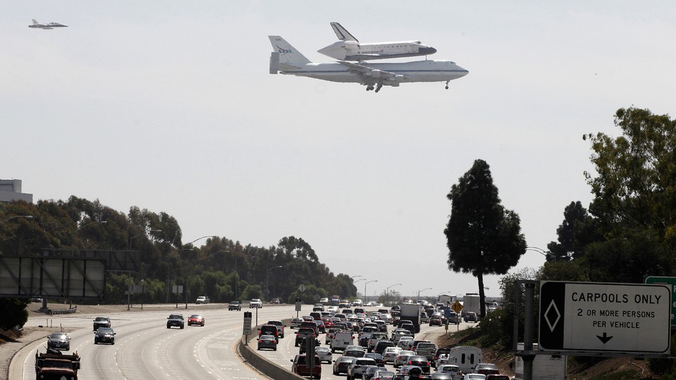 The Shuttle and its escort fly over traffic on the 405 freeway in Los Angeles, 2012.