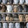 Mannequin heads sitting on a shelf in a factory 